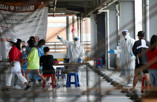 22일 광주 북구보건소 선별진료소에서 의료진이 신종 코로나바이러스 감염증(코로나19) 검사를 받는 시민들을 안내하고 있다.   연합뉴스